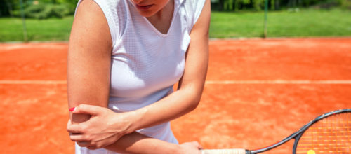 Une image montrant une joueuse de tennis se tenant le coude, visiblement atteinte de douleur